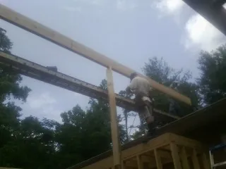Carpenter setting a ridge beam over a new addition frame — Ice Dam Removal by Roofing Brothers in Temecula